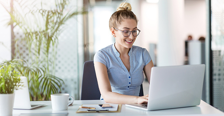 mulher de oculos trabalhando em laptop