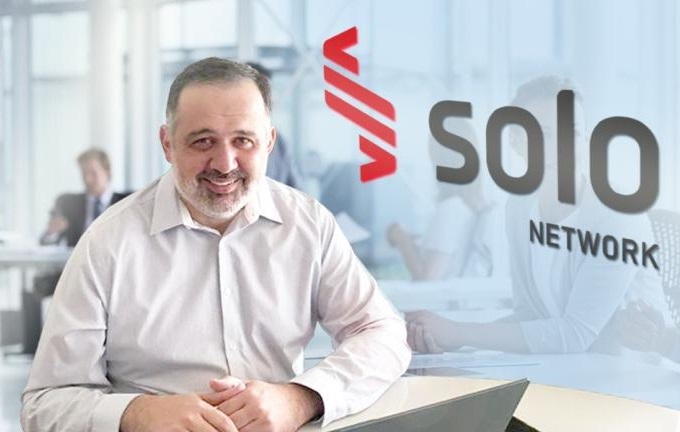Diretor comercial da Solo Network Diretor comercial da Solo Network sentado em seu escritório com pessoas ao fundo